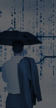 Businessman with an umbrella looking at a giant key with blue sky on the background